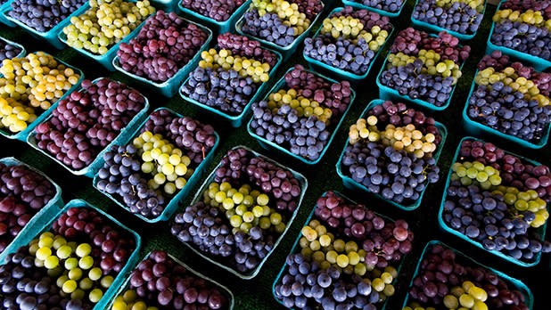 Rows of colorful grapes displayed at Joseph's Wayside Market in Naples