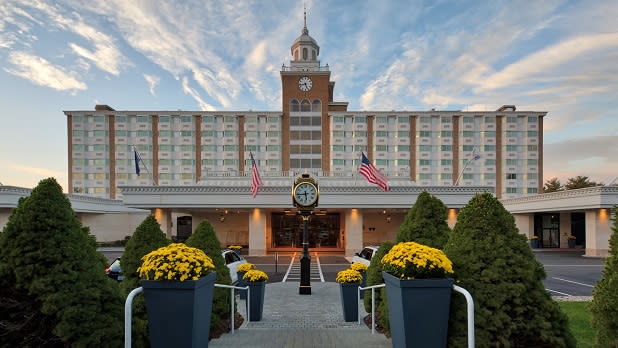 Potted yellow mums line the walkway up to the Garden City Hotel