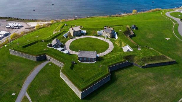 Star-shaped Fort Ontario surrounded by green grass and blue waters from the lake