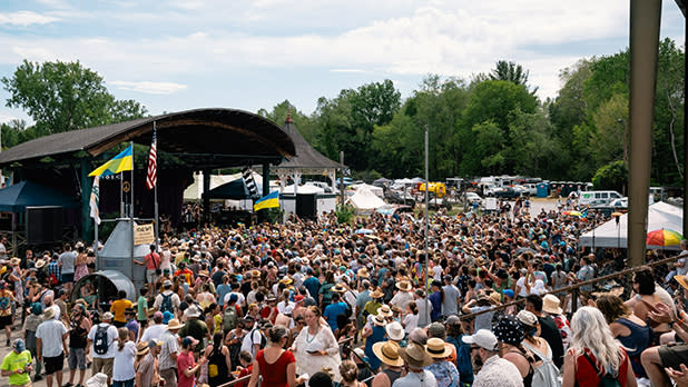 People gather in front of a stage flanked by Ukrainian flags at the Finger Lakes GrassRoots Festival of Music and Dance