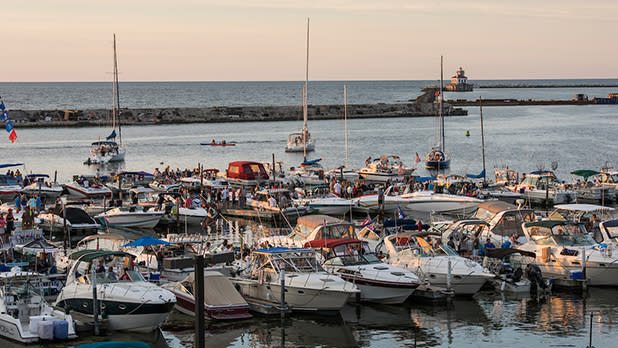 Numerous boats are anchored in a busy harbor at Oswego Harborfest, creating a picturesque view of maritime activity.