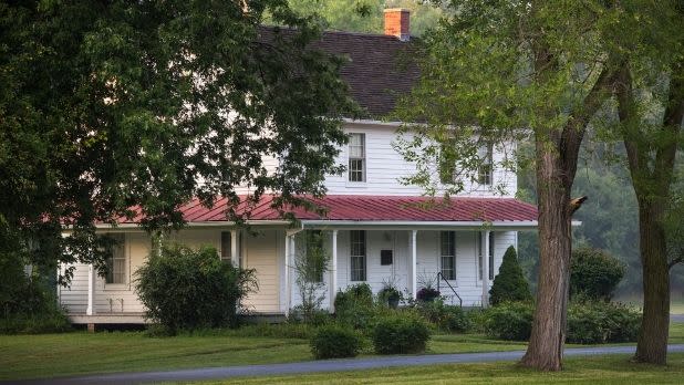 Harriet Tubman's white and red roofed home amid trees and green grass