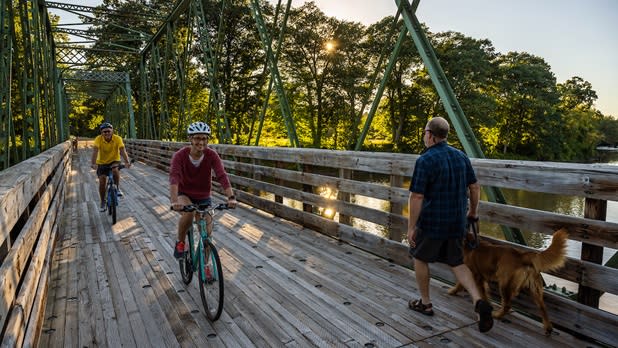 People walking and biking over a bridge at Hudson Crossing Park