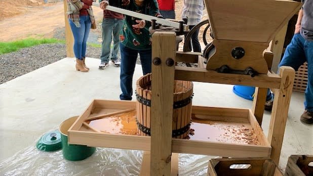 A woman used a hand cider press at the Time And The Valleys Museum