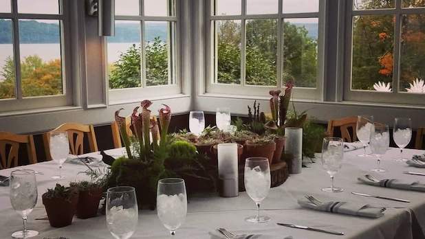 A table set for a meal with a lake view as the backdrop