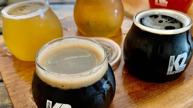 Dark and light beers sit on a tasting flight tray