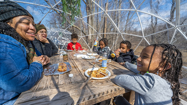 A family enjoys breakfast in an igloo during Maple Weekend at Kettle Ridge Farm