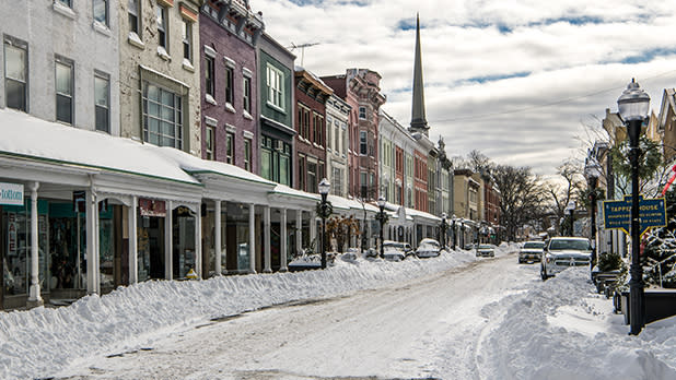 A street covered in snow lined with colorful shops