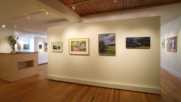 Artwork hangs on a white wall in the Longyear Gallery