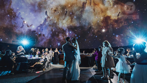 Newlyweds dance under the night sky at the Strasenburgh Planetarium