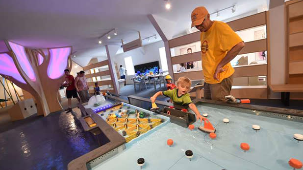 A man and child interact with an exhibit at the North Country Children’s Museum