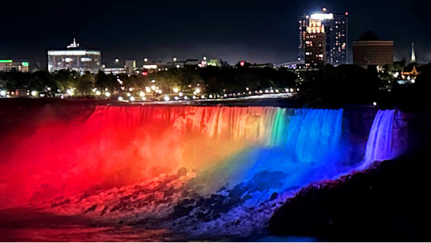 The cascading water of Niagara Falls illuminated in Pride colors