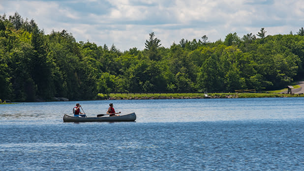 Two people paddling a canoe on a lake.
