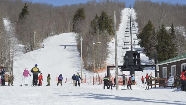 Skiers gathered around at the bottom of a lift at Oak Mountain Ski Center