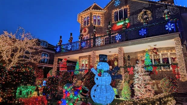A snowman, snowflakes, and other festive decorations adorn a home in Dyker Heights