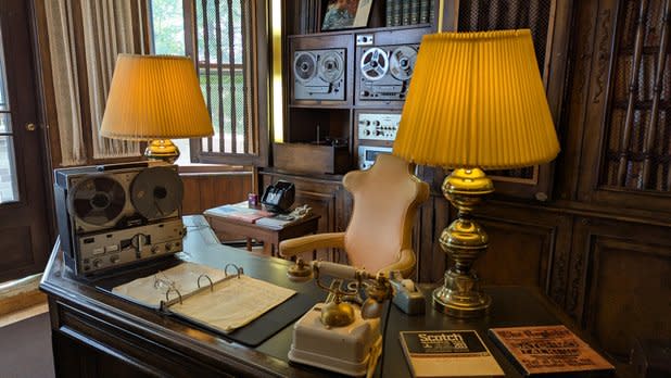 A historic room with a desk, lamps, binder, telephone, and more at the Louis Armstrong House Musuem