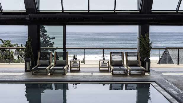view looking out at the ocean out the large windows surrounding the Gurney's Montauk indoor pool.