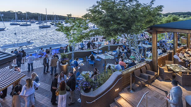 People gather at the Wave Bar to enjoy food and drinks with views of Huntington Harbor at  Prime, An American Kitchen & Bar in Huntington