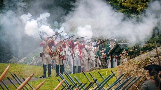 a reenactment of a group of Revolutionary War soldiers firing guns