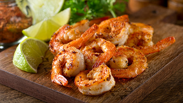 Roasted shrimp and limes on a cutting board