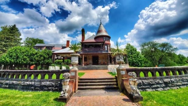 Exterior of the mansion at Sonnenberg Gardens surrounded by vibrant green vegetation