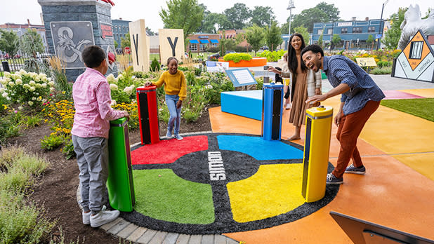 A family plays at a life size display of the classic Simon electronic game at Hasbro Game Park outside the Strong National Museum of Play