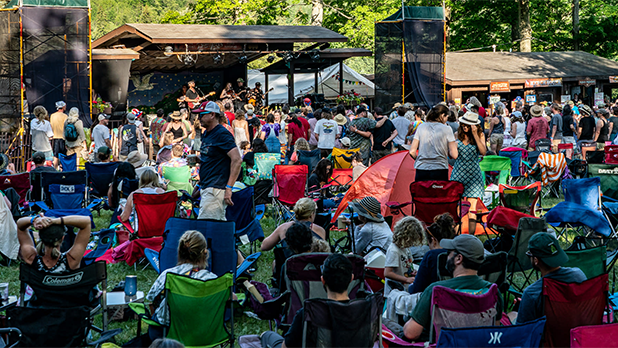 An audience sits in camp chairs at a stage at the Photo courtesy of the Great Blue Heron Music Festival