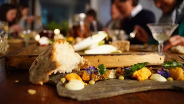 Nicely plated food on a table, people out of focus in the background