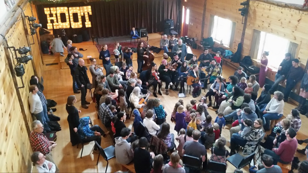 A photo of people gathered in a circle celebrating and having fun at the Winter Hoot in the Catskills