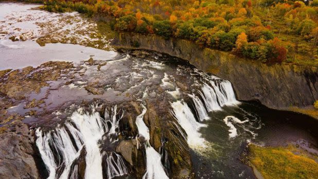 Fall foliage surrounding a large waterfall