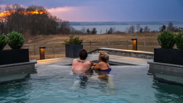 Couple in pool looking out at sunset