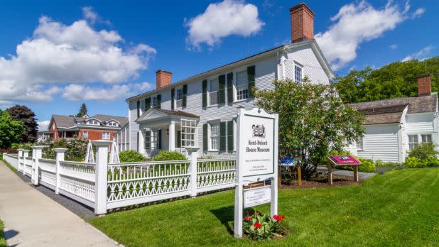 Exterior of Kent-Delord Museum surrounded by white fence and flowers