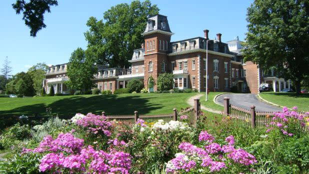 Exterior of Mansion House with pink flowers surrounding it