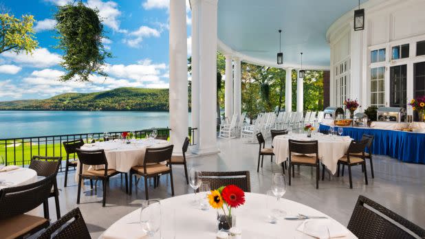 Outdoor dining setting on balcony at Otesaga overlooking lake