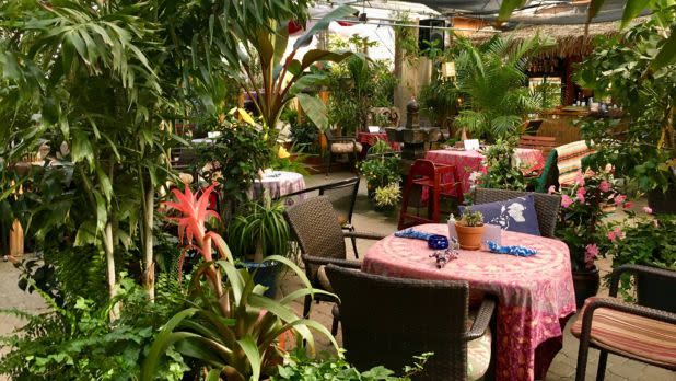 Dining tables nestled in a green lush garden setting