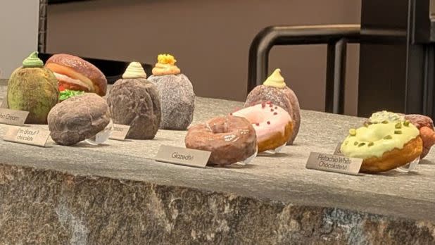 a countertop display of various color and flavor artisan donuts