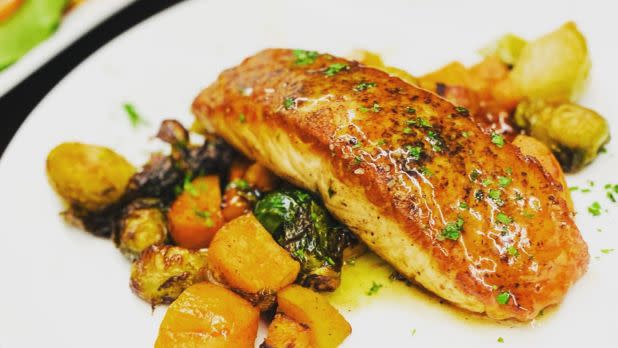 Plate of seared salmon over vegetables