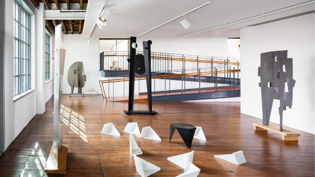 A display of white sculptures on the ground and tall black sculptures at The Noguchi Museum