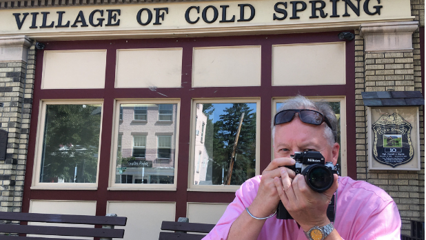 A photo of Official I LOVE NY Leaf Peeper Bill with his camera outside in Village of Cold Spring