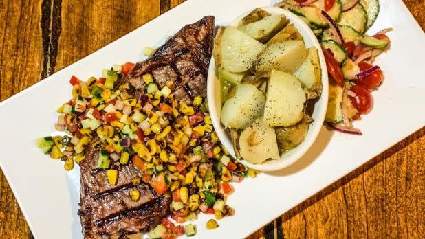 steak, corn, potatoes, vegetables displayed nicely on a plate