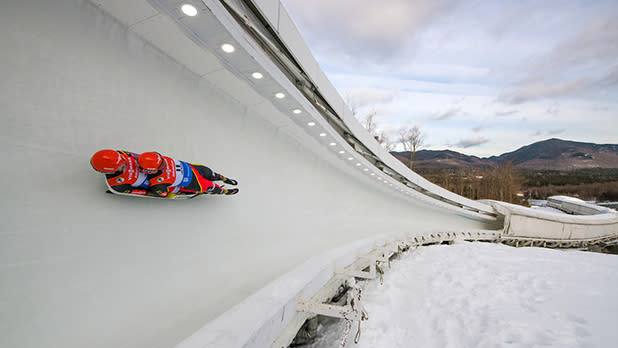 Two people on sled racing down the luge track at Mt Van Hoevenberg