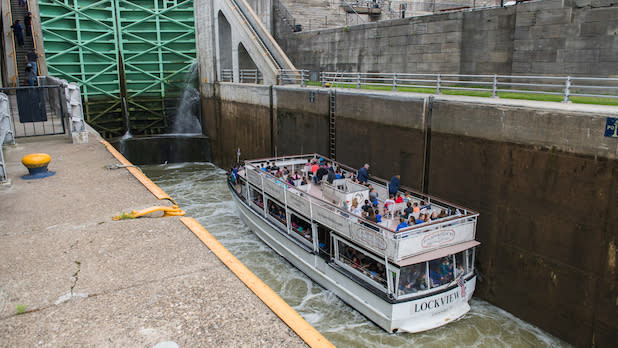 A tour boat floats on the canal, preparing to pass through a lock