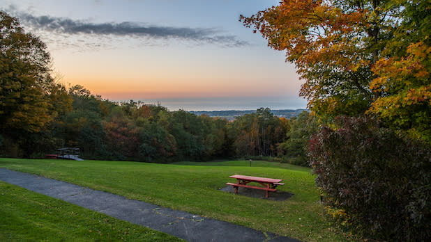 view of the overlook at Luensman Park looking out at orange foliage and Lake Erie in the distance