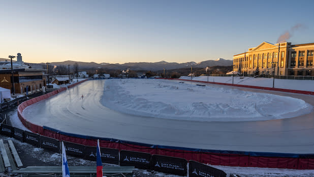 The Olympic Speed Skating Oval in winter with the Adirondack mountains in the distance at sunset