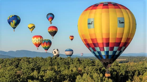 Hot air balloons float in the sky during the Adirondack Balloon Festival