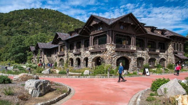 exterior of the Bear Mountain Inn with a view of green mountains in the background