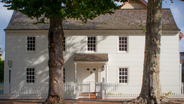 exterior of the Raynham Hall Museum with two trees in front of it