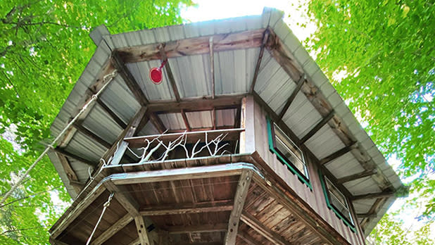 The magical treehouse at Adirondack Adventure Base surrounded by bright green leaves