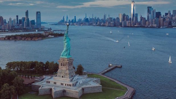 Aerial of Statue of Liberty with the city skyline in the background