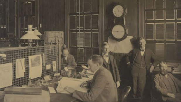 Faded and historic photograph of men working in an office